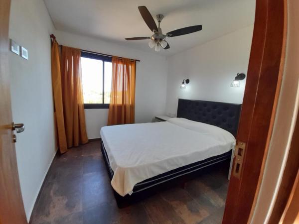 1 dormitorio con 1 cama y ventilador de techo en YMG Appart en Mar de Ajó