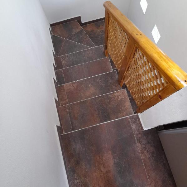 vistas a una escalera de madera con azulejos marrones en YMG Appart en Mar de Ajó