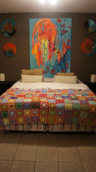 1 dormitorio con 1 cama con una manta colorida en Espectacular departamento en zona residencial en Mendoza