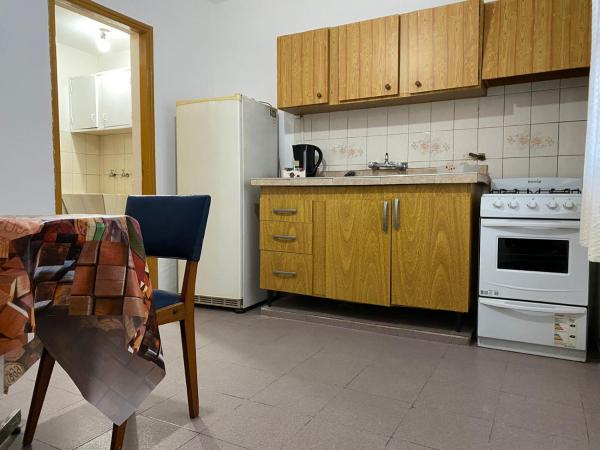 cocina con armarios de madera y refrigerador blanca en Departamento en Mendoza para Linda Estadía en Mendoza