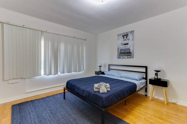 1 dormitorio con 1 cama con manta azul y ventana en 2 Bedroom Mid-Wilshire Charmer close to Downtown, en Los Ángeles