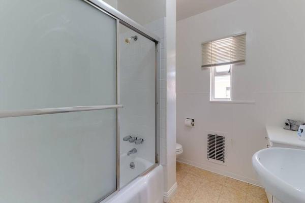 baño blanco con ducha y lavamanos en 2 Bedroom Mid-Wilshire Charmer close to Downtown, en Los Ángeles