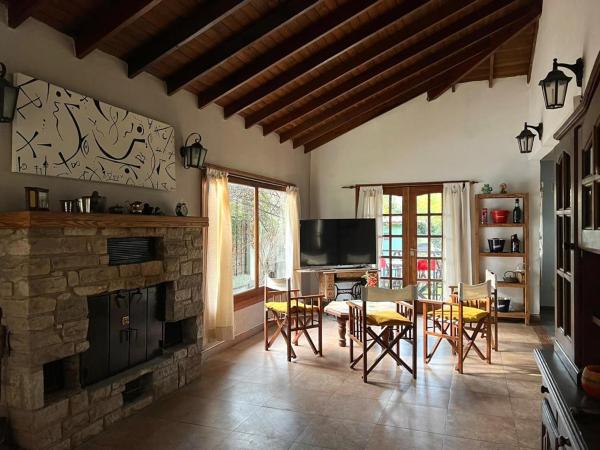 sala de estar con chimenea, mesa y sillas en ENCANTO DEL BOSQUE Casa Bosque Peralta Ramos en Mar del Plata