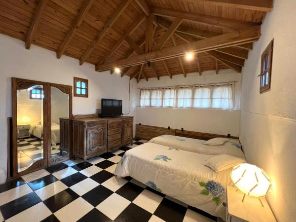 1 dormitorio con 1 cama y TV en ENCANTO DEL BOSQUE Casa Bosque Peralta Ramos en Mar del Plata