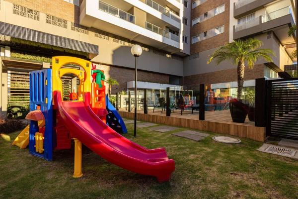 un parque infantil con un tobogán frente a un edificio en Terrazzo Club Residence 407-B - Apartamento em Bombas - Edifício com Jacuzzi - Piscina - Quadra Poliesportiva, en Bombinhas
