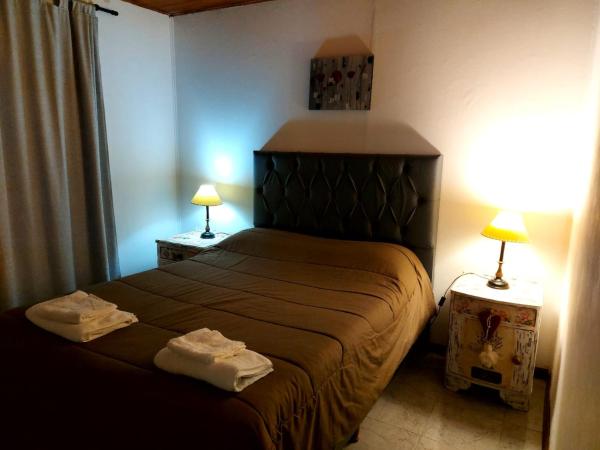 1 dormitorio con 1 cama con 2 toallas en Cabaña VGB. en Villa General Belgrano