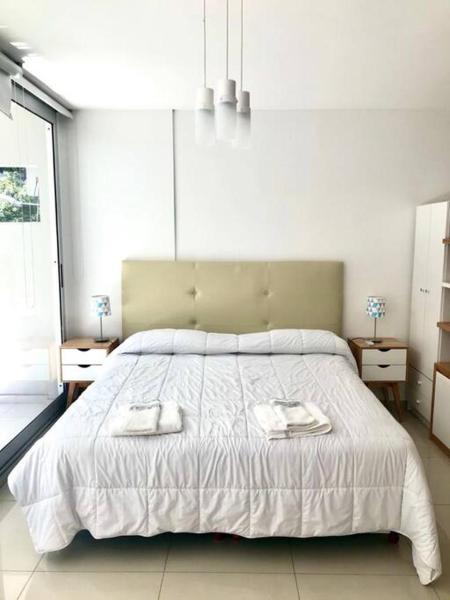 1 dormitorio con 1 cama grande y 2 toallas. en Departamento en Recoleta - Con pileta, parilla, gym - Piso 2 en Buenos Aires