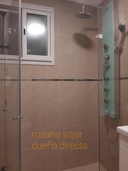 y baño con ducha y puerta de cristal. en Departamento zona plaza Colon en Mar del Plata