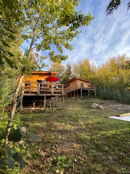 Cabaña de madera con terraza y sombrilla roja en Cabañas San Urbano 1, en Villa Yacanto