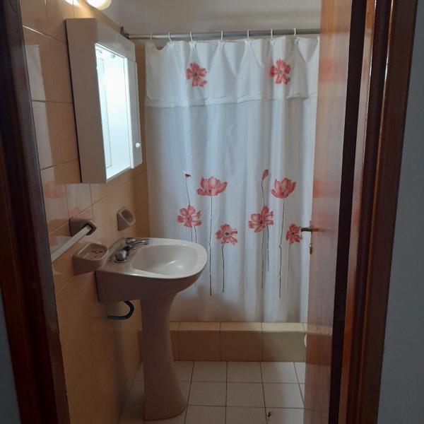 baño con lavabo y cortina de ducha con flores en Casa sur FARO en Mar del Plata