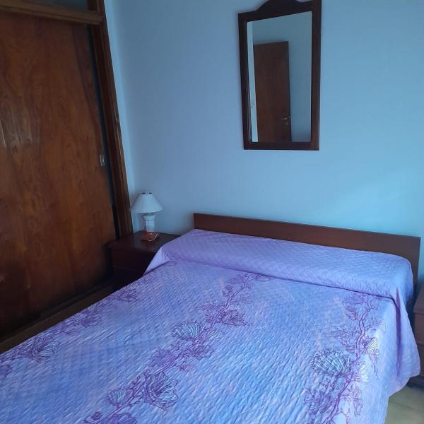 1 dormitorio con cama y espejo en la pared en Casa sur FARO en Mar del Plata