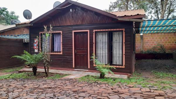 una pequeña casa de madera con puerta y ladrillo en Voces De La Selva Misionera en Puerto Iguazú