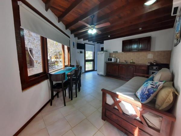 sala de estar y cocina con sofá y mesa en Nereidas Apart en Mar de las Pampas