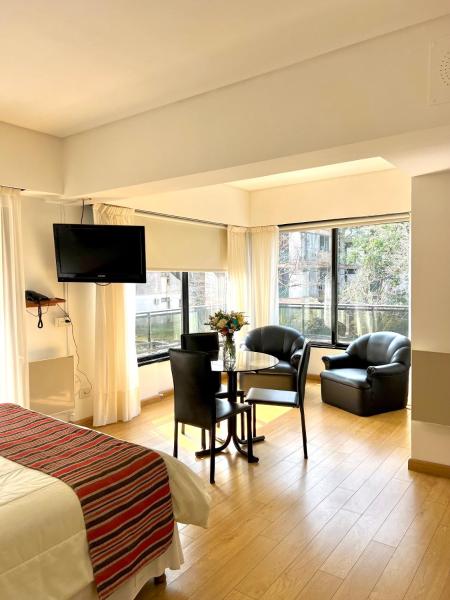 Habitación de hotel con cama, mesa y sillas en Golf Tower Suites & Apartments en Buenos Aires