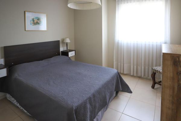 a bedroom with a bed with a blue blanket and a window at Departamento de una dormitorio - CRESPO in Santa Fe