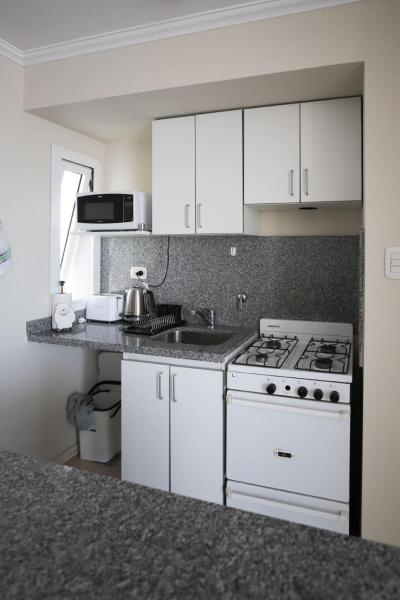 a kitchen with a white stove and a sink at Departamento de una dormitorio - CRESPO in Santa Fe