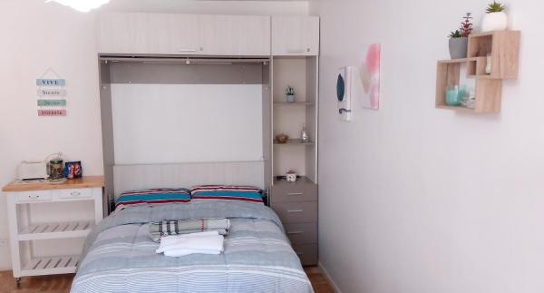 Habitación pequeña con cama y pared blanca en Comfortable Equipped Studio, Strategic Location in Palermo - Amplio Monoambiente en Palermo en Buenos Aires