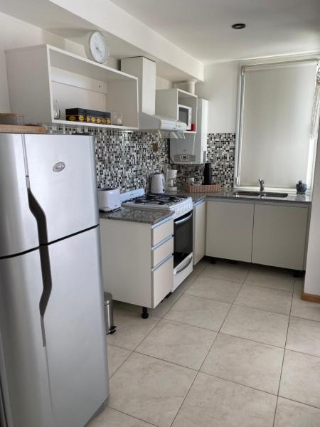 cocina con electrodomésticos blancos y refrigerador blanca en Monoambiente Céntrico único en Puerto Madryn