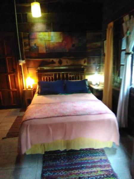 1 dormitorio con 1 cama en una habitación con alfombra en Cabaña El Deseo En El Bosque en Balneario Mar Azul