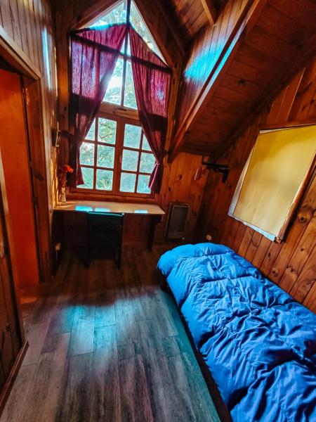 1 dormitorio con 1 cama en una habitación con ventana en Cabaña La Tranquila en San Martín de los Andes
