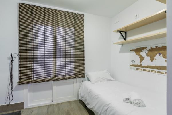 1 dormitorio con cama y ventana grande en The Purple House Alameda, en Sevilla