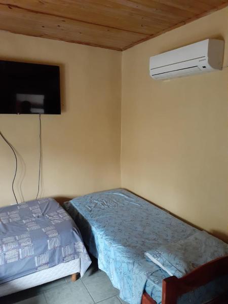 1 dormitorio con 1 cama y TV en la pared en Departamento céntrico completo en Gualeguaychú