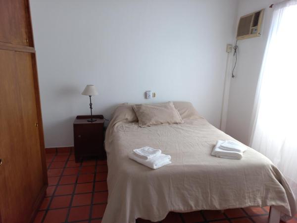 1 dormitorio con 1 cama con 2 toallas en Carnaval en Gualeguaychú