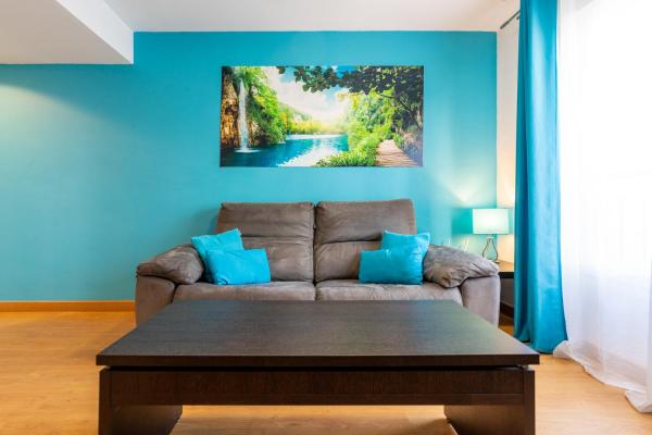 una sala de estar con sofá y una pintura en la pared en San Miguel Centro, en Torremolinos