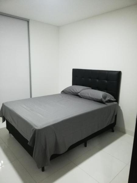 1 cama con cabecero negro en una habitación blanca en Element by Elite, en Santa Cruz de la Sierra