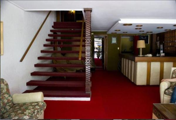 una escalera en una sala de estar con alfombra roja en el Hotel Danubio de Villa Gesell