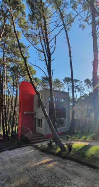 una casa roja y blanca sentada junto a una carretera en EL PINAR CASA DE PLAYA en Balneario Mar Azul