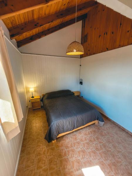 1 dormitorio con 1 cama en una habitación con techos de madera en Los Manzanos en San Martín de los Andes