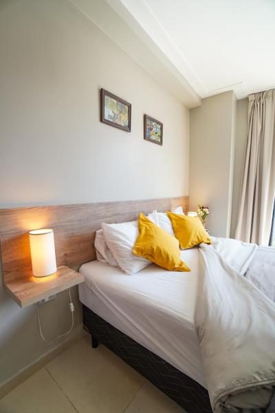 1 dormitorio con 1 cama con almohadas amarillas en Rent for Days IV- Norte Vip en San Miguel de Tucumán