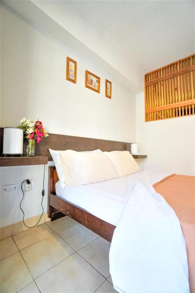 1 dormitorio con 1 cama y 1 mesa con flores en Rent for Days III - Mono Plaza en San Miguel de Tucumán