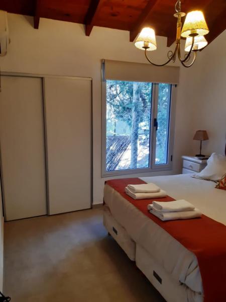1 dormitorio con cama y ventana grande en Cabañas Antares en Mar de las Pampas