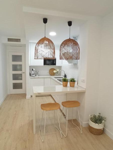 cocina con encimera blanca y 2 taburetes en Luxury apartment Old Town 1Bedroom, en Málaga