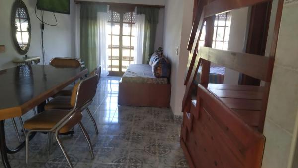 sala de estar con cama, mesa y sillas en Faro departamento lujoso en Mar del Plata