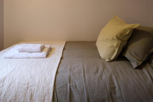 Una cama con una almohada y una toalla. en Oliver Mountain Home Green en San Martín de los Andes
