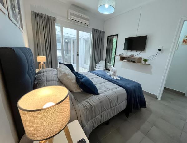 Habitación con cama, sofá y TV. en Hermosa casa estilo nórdico en tranquilo barrio céntrico en Mendoza