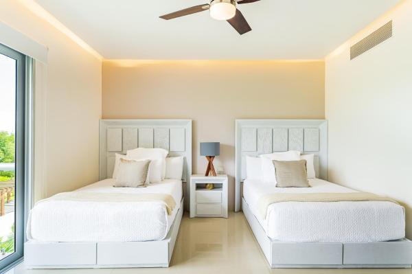 2 camas en un dormitorio con ventilador de techo en Casa Brisas apts, en Playa del Carmen