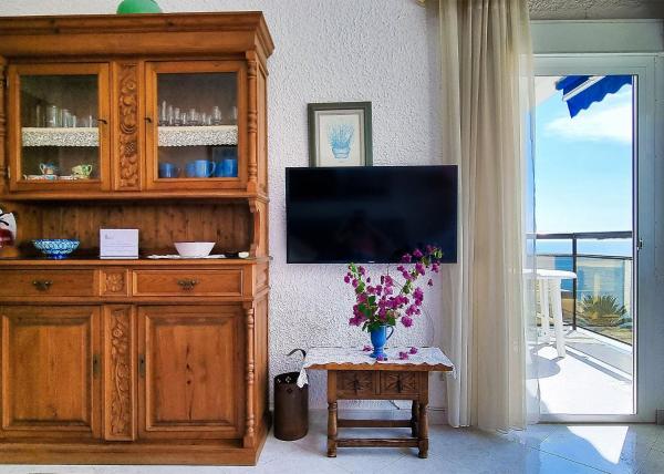 sala de estar con TV y armario de madera en Skol 440. Nice 1 Bed Apartment with Sea Views in Marbella centre., en Marbella