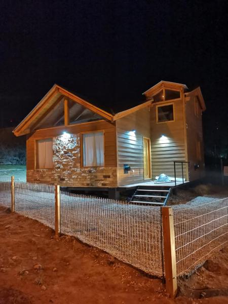 una casa de madera con una valla delante en Los Robles Patagonia en Esquel