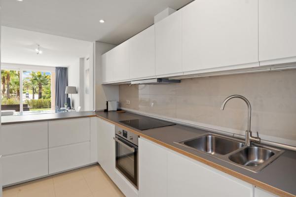 una cocina con armarios blancos y fregadero en Stunning blue lagoon apartment in Estepona M12, en Estepona