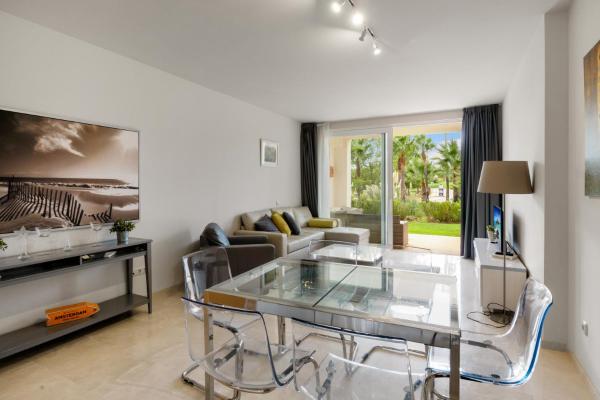 sala de estar con mesa de cristal y sofá en Stunning blue lagoon apartment in Estepona M12, en Estepona