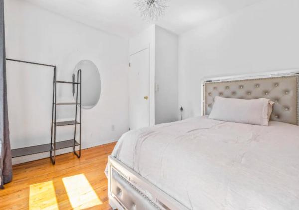 Un dormitorio con una cama blanca y una escalera en Beautiful 3BR 1BA Apartment in Kips Bay, en Nueva York