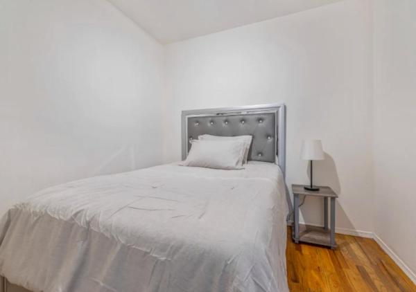 1 dormitorio con 1 cama con colcha blanca en Beautiful 3BR 1BA Apartment in Kips Bay, en Nueva York