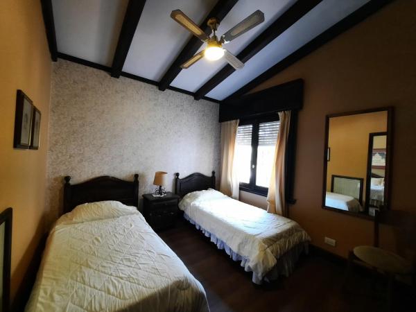 1 dormitorio con 2 camas y ventilador de techo en Posada La Villa en Villa Carlos Paz