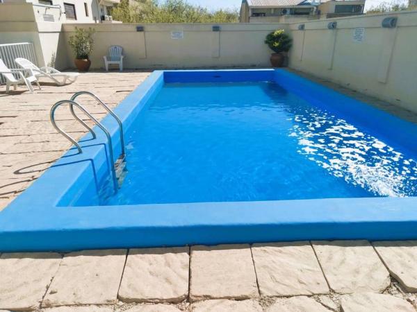 una piscina azul con un patio de azulejos en Estudio / monoambiente ubicación privilegiada en Mendoza