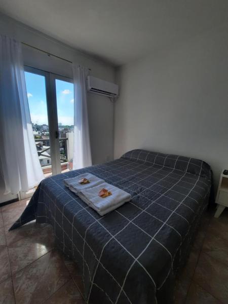 a bedroom with a bed and a large window at Departamento con COCHERA - Santa Fe in Santa Fe