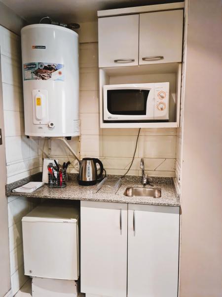 una pequeña cocina con fregadero y microondas en Estudio / monoambiente ubicación privilegiada en Mendoza